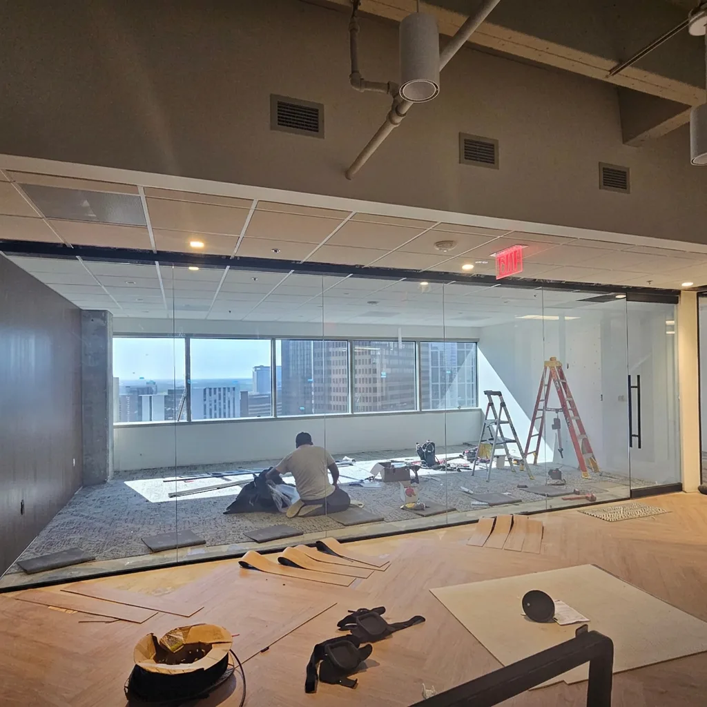 Frameless glass office partition wall with skyline views beyond