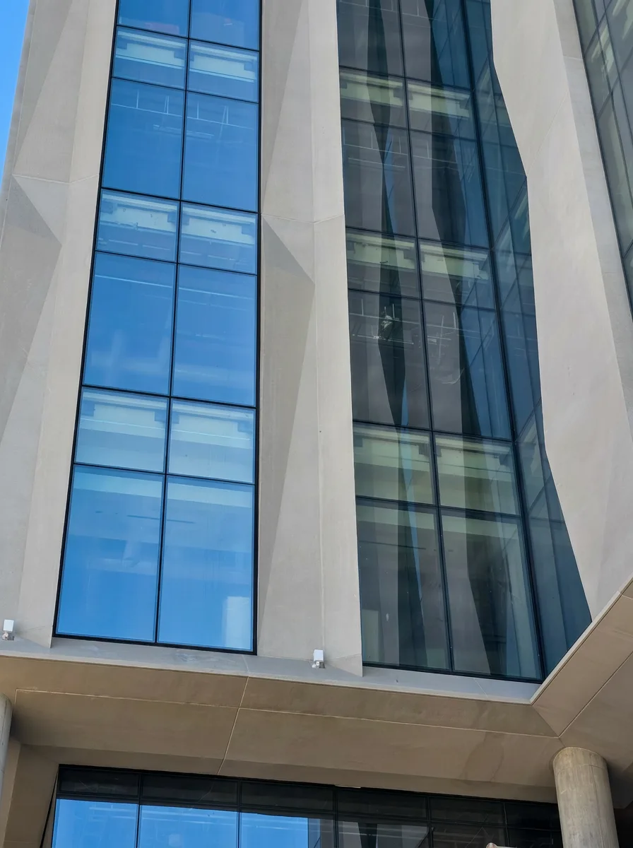 Multi-story commercial curtain wall with stone fins