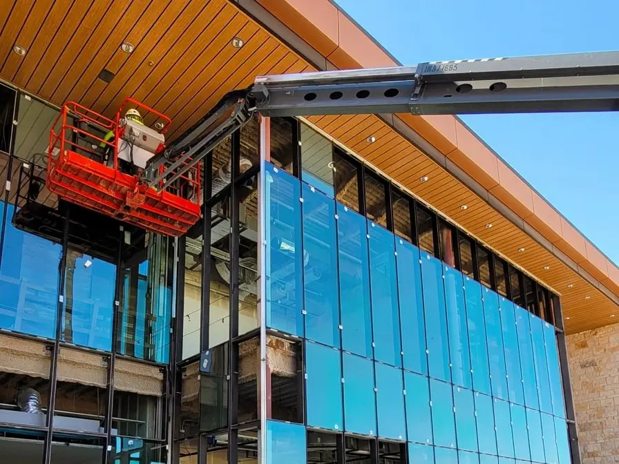 Multi-story commercial curtain wall installation with dark aluminum framing